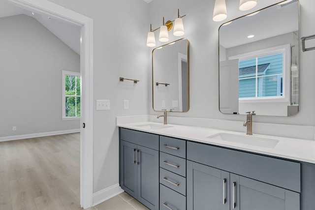 395 Wappoo Trace Ln, Summerville, SC 29486 - bathroom featuring double vanity, lofted ceiling, baseboards, and wood finished floors