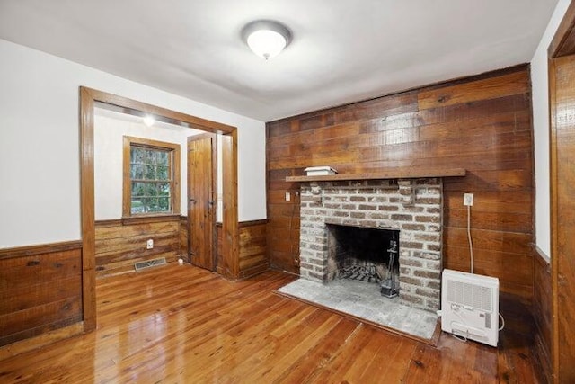 2206 Weepoolow Trl, Charleston, SC 29407 - unfurnished living room with wooden walls, wood finished floors, a brick fireplace, and wainscoting