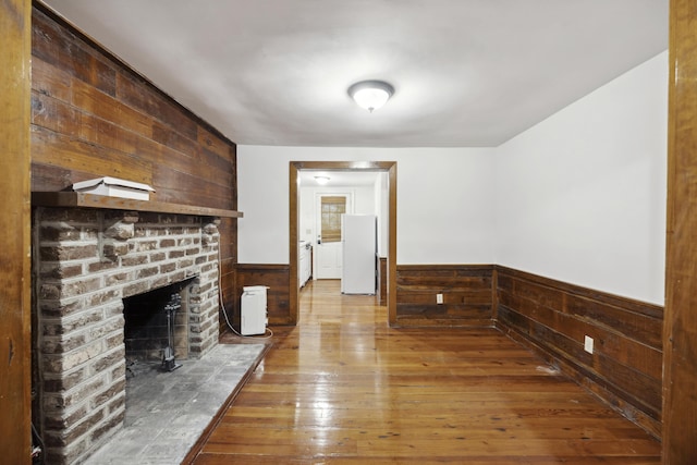 2206 Weepoolow Trl, Charleston, SC 29407 - unfurnished living room with wooden walls, wainscoting, a brick fireplace, and hardwood / wood-style flooring