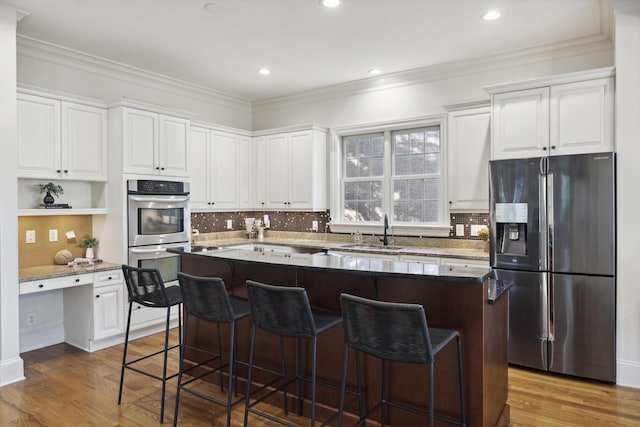 2206 Weepoolow Trl, Charleston, SC 29407 - kitchen with stainless steel appliances, white cabinetry, wood finished floors, crown molding, and recessed lighting