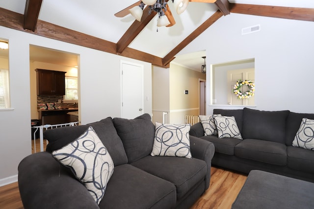 living room featuring ceiling fan, vaulted ceiling with beams, and light hardwood / wood-style floors