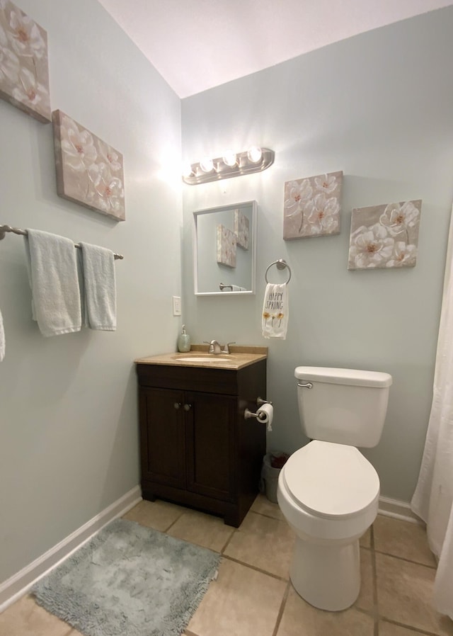 bathroom featuring toilet, vanity, and tile patterned flooring