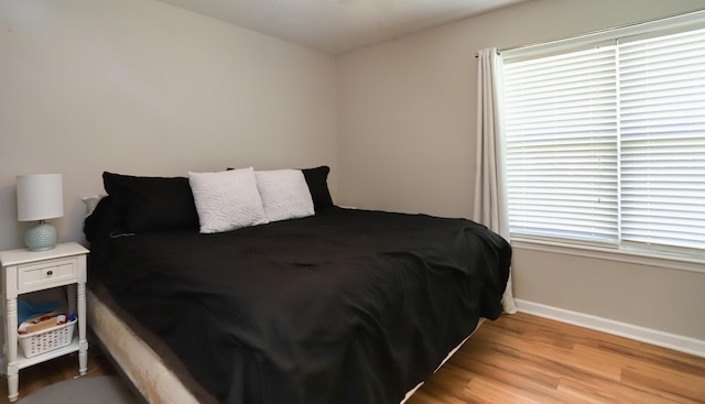 bedroom with light hardwood / wood-style floors and multiple windows