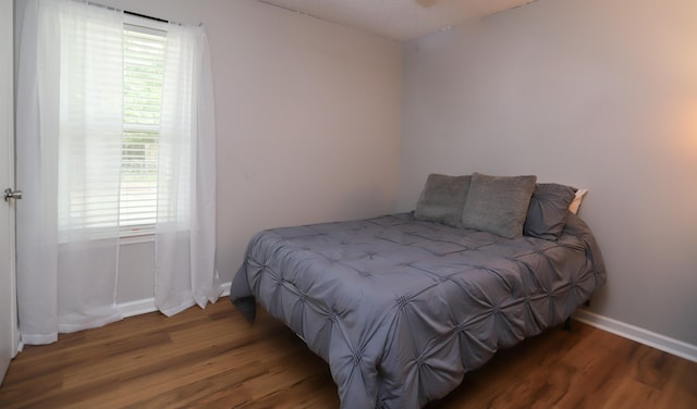 bedroom featuring dark wood-type flooring and multiple windows