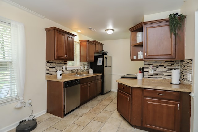 kitchen featuring tasteful backsplash, a healthy amount of sunlight, sink, and stainless steel appliances