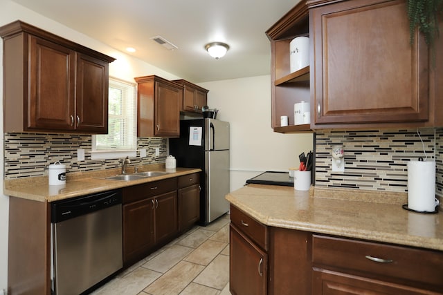 kitchen with appliances with stainless steel finishes, backsplash, and sink