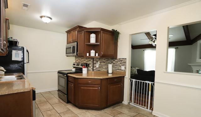 kitchen with light tile patterned floors, ceiling fan, appliances with stainless steel finishes, decorative backsplash, and dark brown cabinets