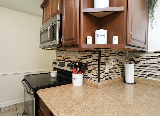 kitchen with appliances with stainless steel finishes and backsplash