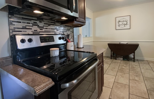 kitchen with light tile patterned floors, stainless steel appliances, decorative backsplash, and dark brown cabinets