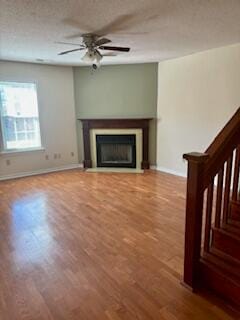 unfurnished living room featuring hardwood / wood-style floors and ceiling fan