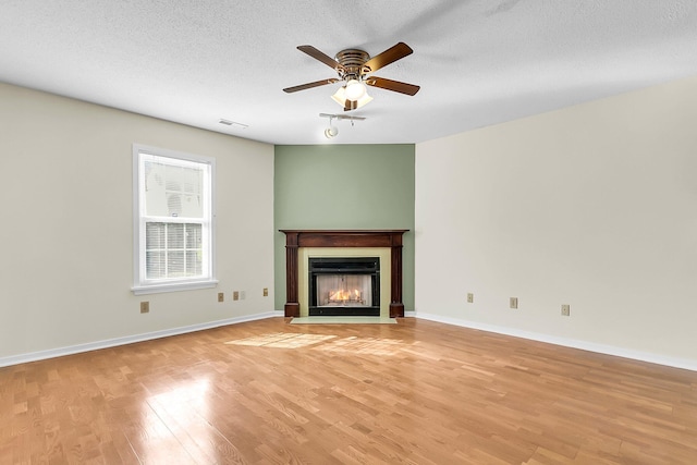 unfurnished living room featuring a textured ceiling, light hardwood / wood-style flooring, and ceiling fan