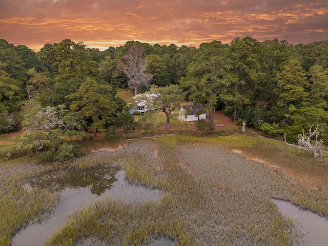 aerial view at dusk featuring a water view