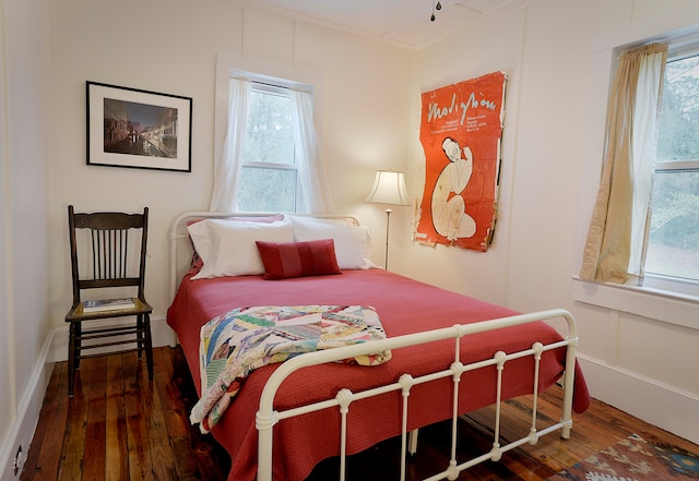 bedroom featuring multiple windows and dark wood-type flooring