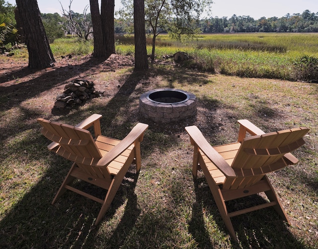 view of community with an outdoor fire pit and a rural view