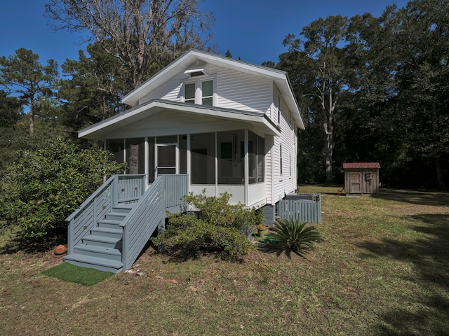 bungalow-style house with a shed, a front lawn, and a sunroom