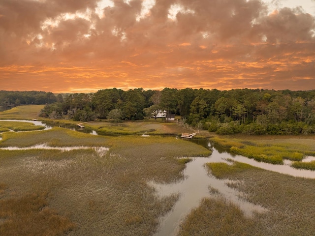 aerial view at dusk featuring a water view