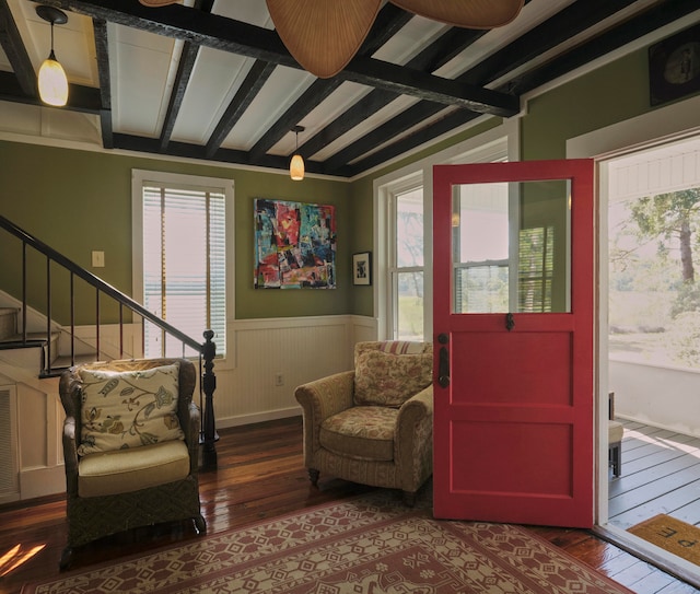 sitting room with beam ceiling and wood-type flooring