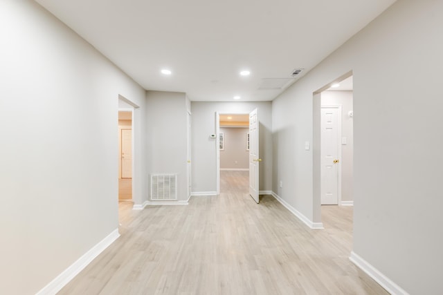 corridor with light hardwood / wood-style floors