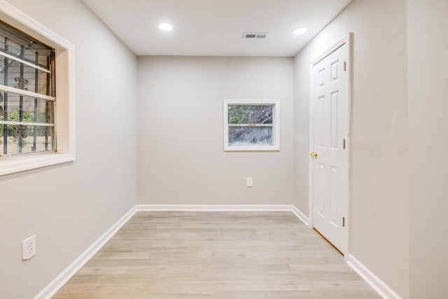 empty room with plenty of natural light and light hardwood / wood-style floors