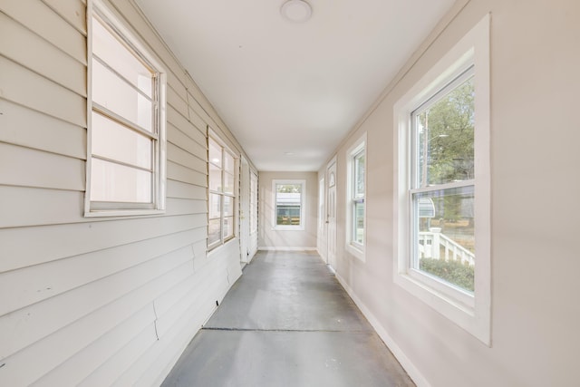 hallway with a wealth of natural light and concrete floors