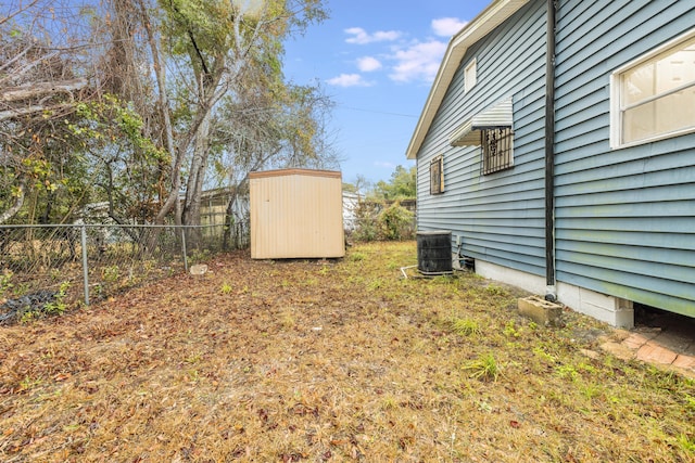 view of yard with a storage shed and central AC