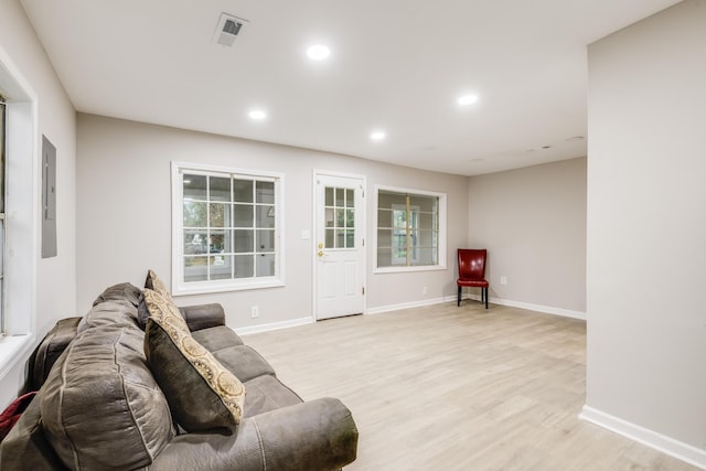 living room featuring electric panel and light hardwood / wood-style flooring