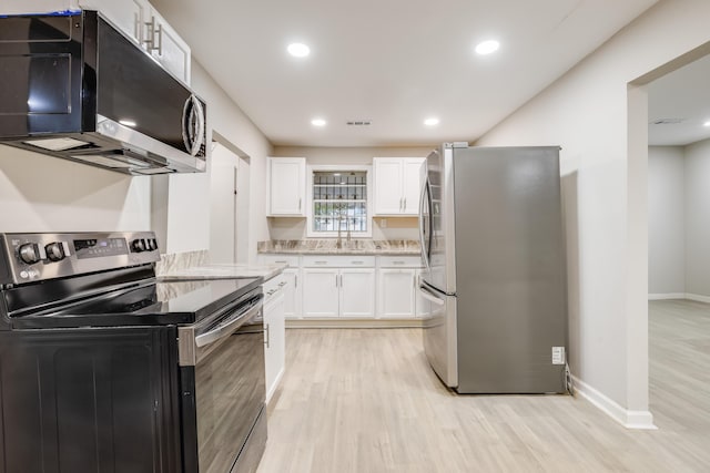 kitchen with sink, white cabinets, light wood-type flooring, and appliances with stainless steel finishes