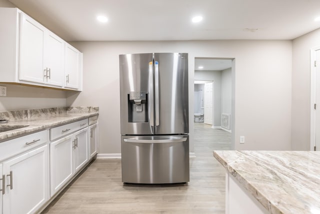 kitchen with white cabinets, light hardwood / wood-style floors, and stainless steel refrigerator with ice dispenser