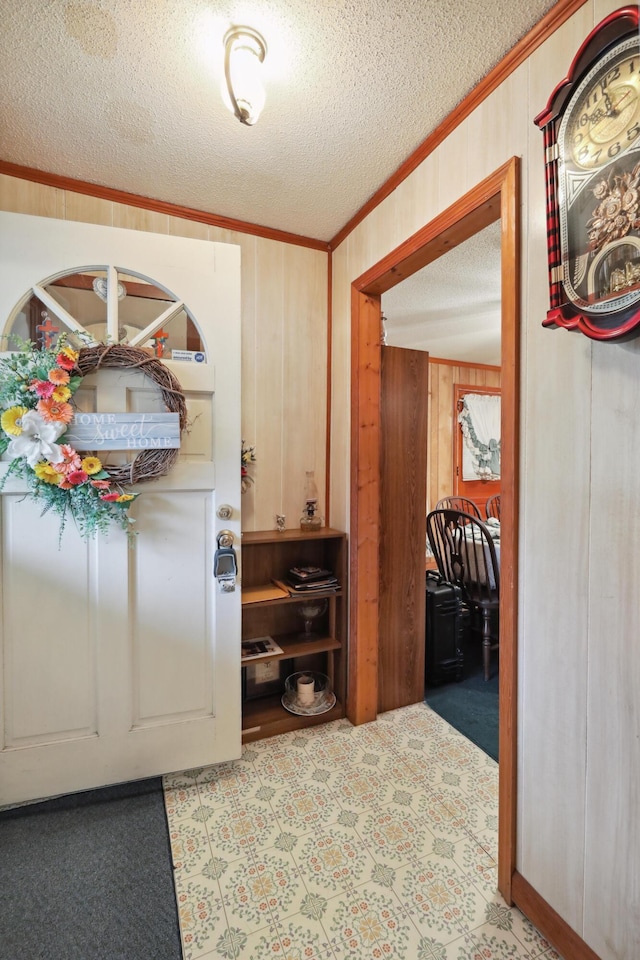 hall featuring crown molding, wooden walls, light carpet, and a textured ceiling