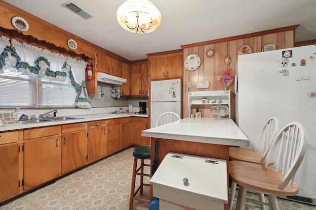 kitchen with white refrigerator, fridge, a center island, and a breakfast bar area