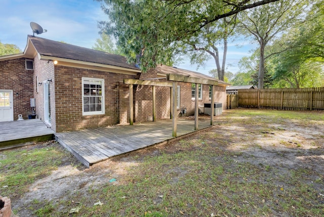 rear view of property with brick siding, a fenced backyard, a pergola, and a deck