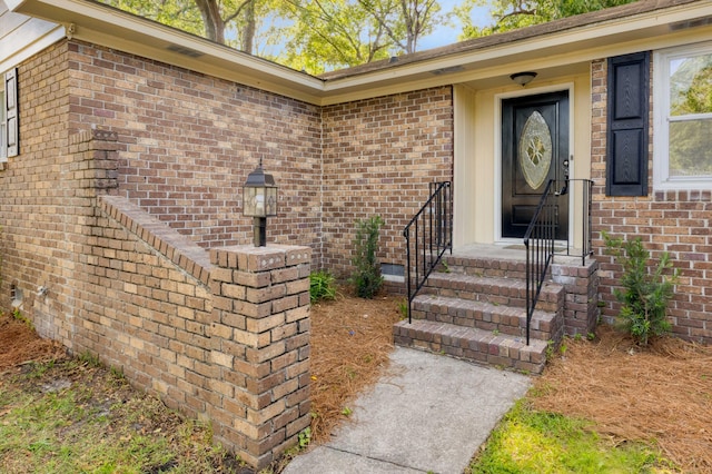 doorway to property featuring brick siding
