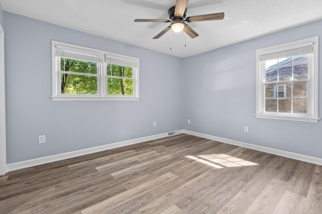 spare room featuring baseboards, a ceiling fan, and wood finished floors