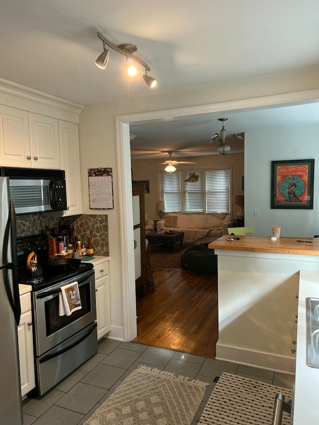 kitchen with tile patterned flooring, decorative backsplash, white cabinetry, and stainless steel appliances