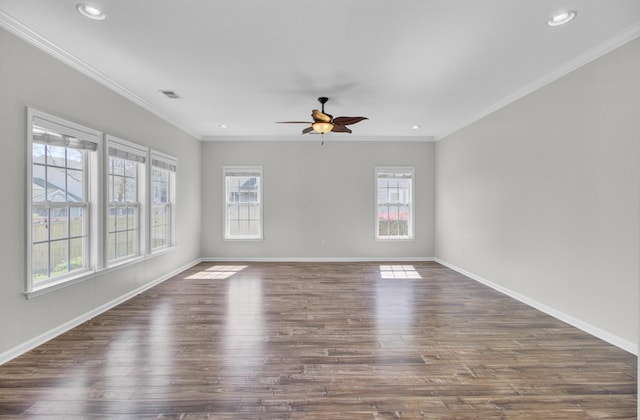 spare room featuring a wealth of natural light, visible vents, dark wood finished floors, and ceiling fan