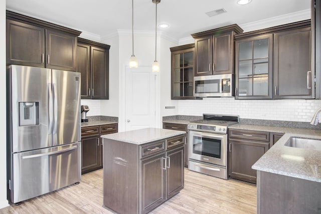 kitchen with a sink, stainless steel appliances, visible vents, and dark brown cabinets