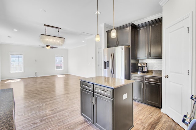 kitchen featuring decorative backsplash, a ceiling fan, stainless steel refrigerator with ice dispenser, and ornamental molding