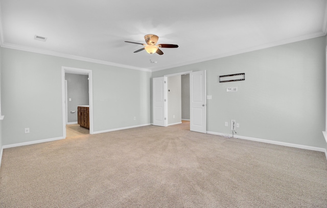 empty room featuring ornamental molding, light colored carpet, baseboards, and ceiling fan