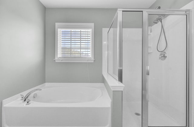 bathroom featuring a bath and a shower stall