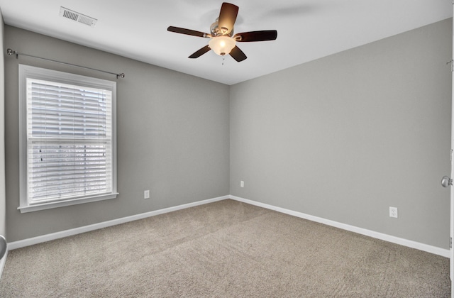 spare room with visible vents, baseboards, ceiling fan, and carpet floors