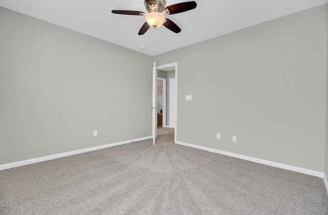 carpeted empty room featuring baseboards and ceiling fan