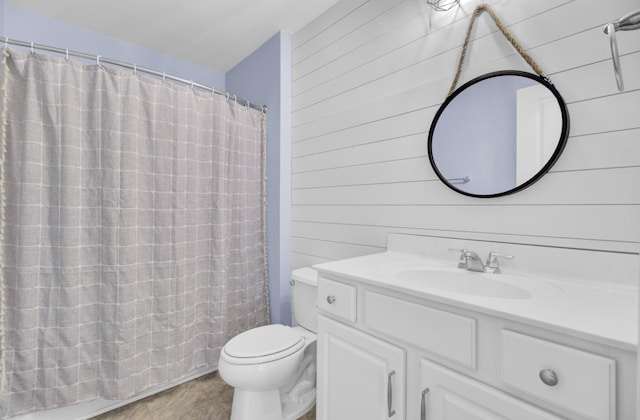 bathroom with vanity, a shower with curtain, tile patterned flooring, wood walls, and toilet