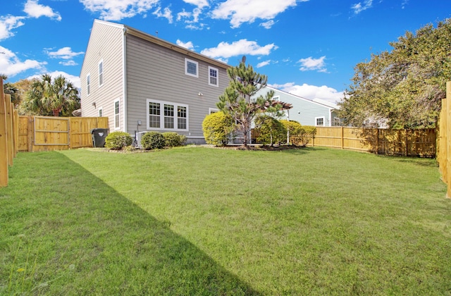 back of property featuring a lawn and a fenced backyard