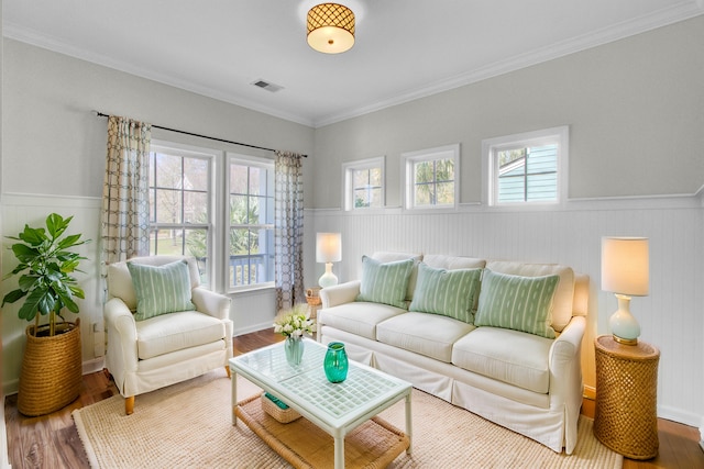 living area with a wealth of natural light, visible vents, and wood finished floors