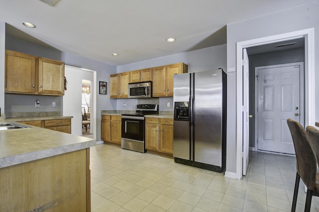 kitchen featuring sink, light tile patterned floors, and stainless steel appliances