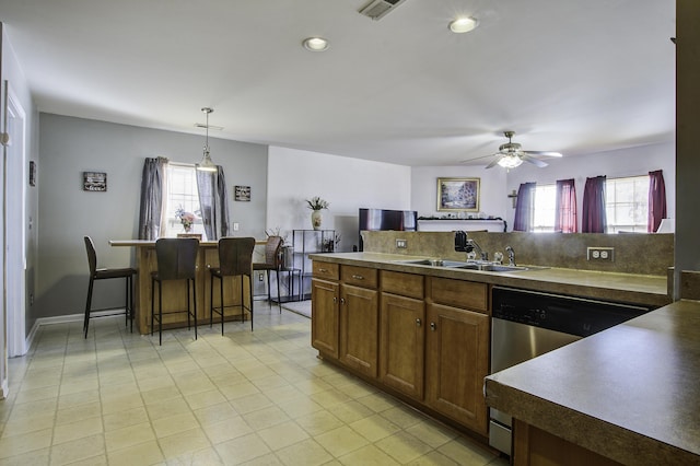 kitchen featuring decorative light fixtures, a healthy amount of sunlight, dishwasher, and sink