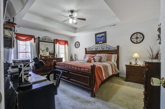 bedroom with carpet, ceiling fan, and a tray ceiling