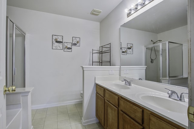 bathroom with tile patterned flooring, vanity, toilet, and a shower with door