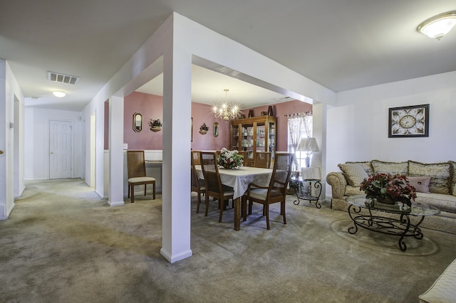 carpeted dining area featuring an inviting chandelier