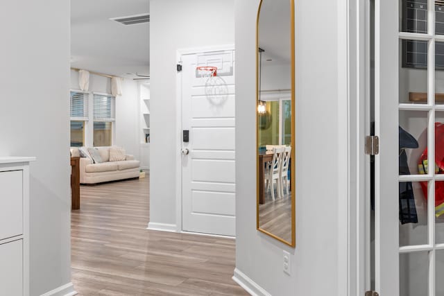 hallway with light hardwood / wood-style floors